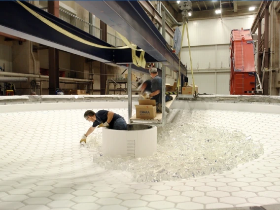 Technicians loading chunks of glass onto the honeycomb casting mold